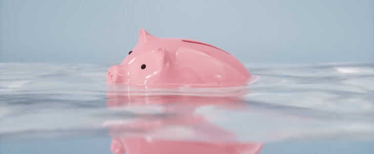 Sinking piggy bank in the water.